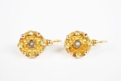 a pair of gold earrings with pearls and a pearl bead