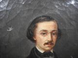 portrait of a man with a mustache and glasses in a black suit
