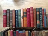 many books that are on a shelf in a library