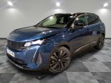 le 4x4 bleu est garé sur le sol en damier d'un garage