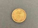 a close up of a gold coin on a gray surface