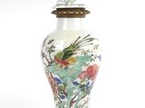 un vase avec un oiseau posé sur une table