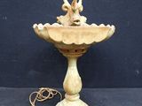 an image of a bird on top of a birdbath on a table