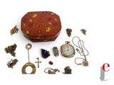 a small red box with a bunch of jewelry on it