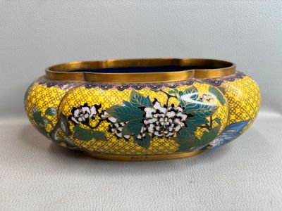 une image représentant un vase jaune et bleu orné de fleurs