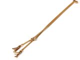 a close up of a gold chain bracelet with a tassel