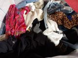 a suitcase full of clothes and clothes sitting on a bed