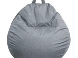 un pouf gris posé sur un sol blanc