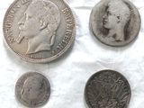 Plusieurs pièces de monnaie sont posées sur un morceau de papier, sur une table.