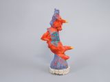 figurine of a red and blue bird sitting on top of a white base