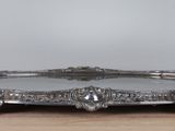 a silver tray with a handle on a wooden table
