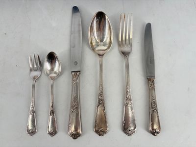 a silverware set on a table with a knife, fork, spoon, and spoon rest