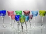 many different colored wine glasses lined up on a table