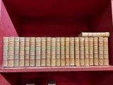 de nombreux livres anciens sur une étagère rouge dans une pièce rouge