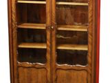 une photo d'une bibliothèque en bois avec des portes vitrées et des étagères