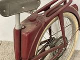 a red bike with a black seat sitting on the floor