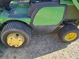 a picture of a green and black lawn mower parked on the side of the road