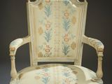 an old chair with a floral pattern on the back of it