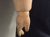 a doll that has a hand on it ' s arm