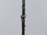 a black and white clarinet sitting on top of a clear stand