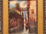 painting of a canal scene with a gondola in a gold frame