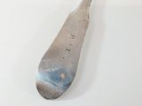 a silver spoon with writing on it sitting on a table