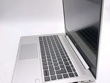 a silver laptop computer sitting on a white surface