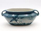 a blue and white bowl with a bird design on it