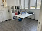 un bureau blanc sur lequel est posé un ordinateur portable, dans une pièce