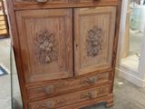 une armoire en bois ornée de sculptures, dans un magasin