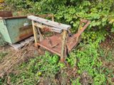 une vieille chaise rouillée et une poubelle dans l'herbe