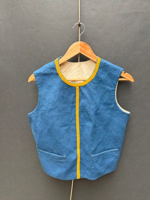 un gilet bleu orné d'une rayure jaune, suspendu à un cintre