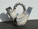 a white and blue vase with a black cat on it