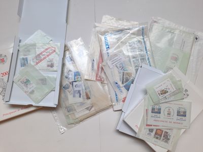 Plusieurs enveloppes et timbres sont posés sur une table blanche.