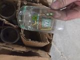 a person holding a bottle of water in a cardboard box