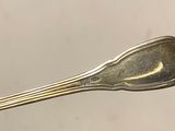 a silver spoon with a long handle on a table