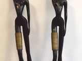 une paire de statues noires et dorées représentant une femme et un homme