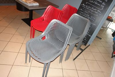 trois chaises placées devant un tableau noir dans un restaurant