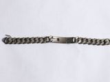 a close up of a metal bracelet on a white surface