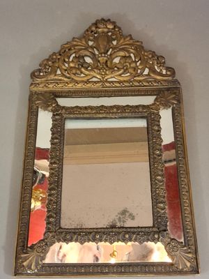 un miroir accroché au mur avec un cadre doré