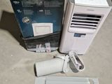 a small air conditioner sitting on the floor next to a box