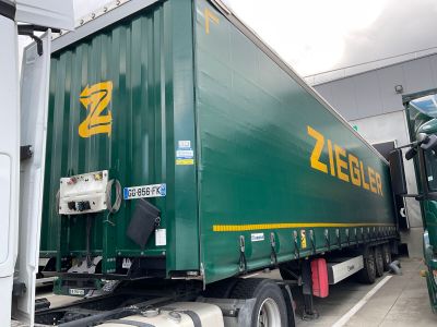 a large green semi truck parked in a parking lot