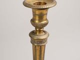 an antique brass candle holder on a white background