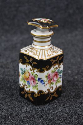 an image of a small black and white bottle with flowers on it