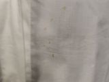 a close up of a white shirt with a stain of paint on it
