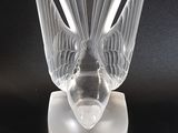 un vase en verre transparent surmonté d'un oiseau