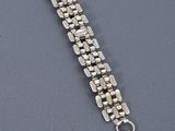 a close up of a bracelet with a chain on a table