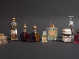 sept petites bouteilles de différentes couleurs et tailles posées sur une table
