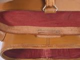 a close up of a brown bag with a red lining