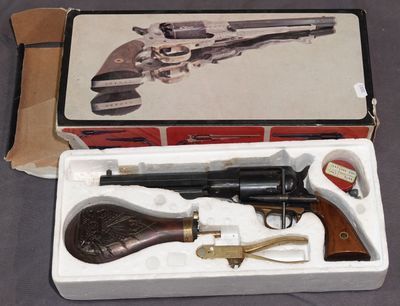 une boîte contenant un pistolet, posée sur une table